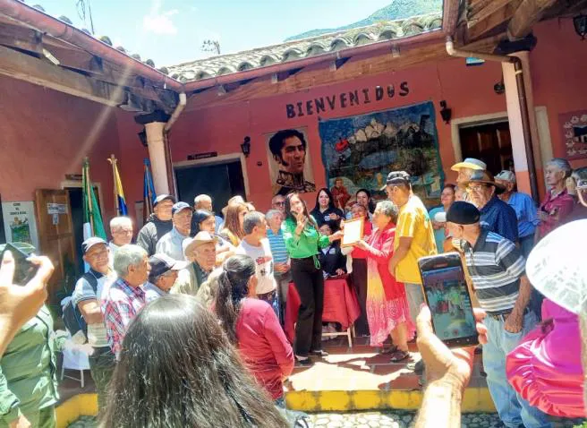 Entrega de la Placa de Reconocimiento a uno de los adultos mayores homenajeados.