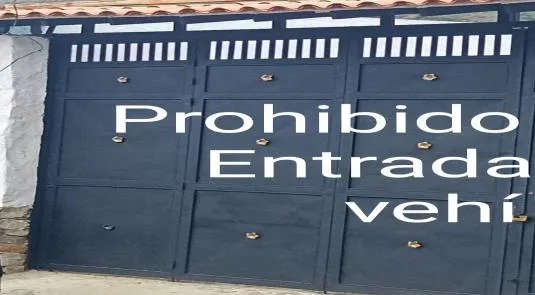 Con una sola hoja abierta, el portón decía: «Prohibido. Entrada de vehí».