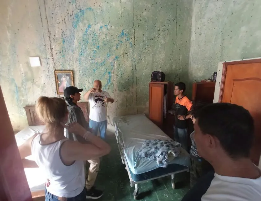 El equipo revisa la habitación donde se grabarán las escenas: paredes desconchadas, una cama de hospital y un cuadro religioso.