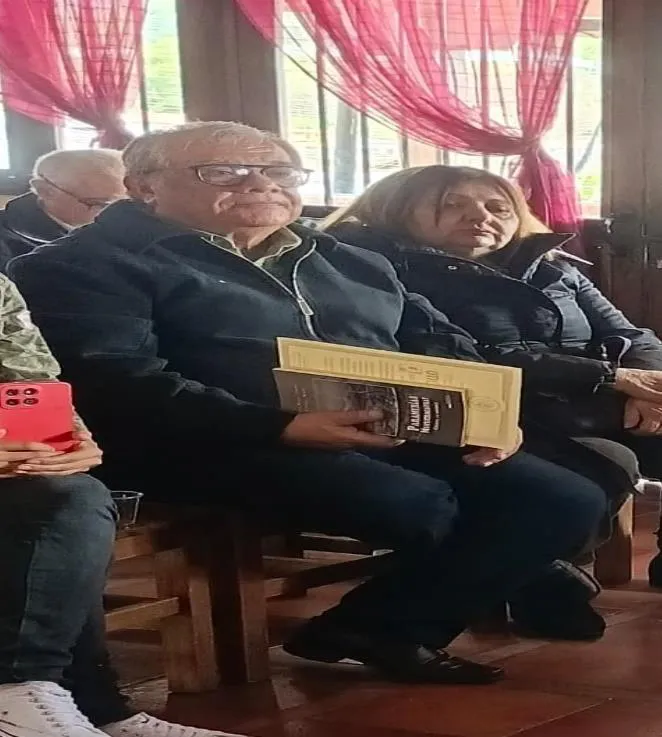 El homenajeado sentado entre el público, con los libros que le obsequiaron sobre las piernas; entre ellos, «Paramerías Mucuchacayhay».