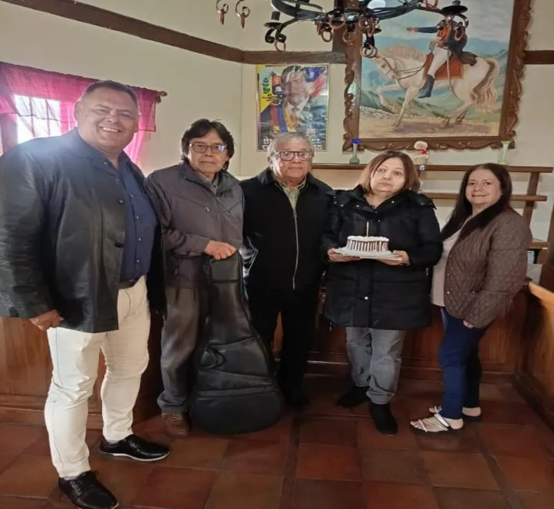 Cinco de los asistentes posan con la torta del homenaje.