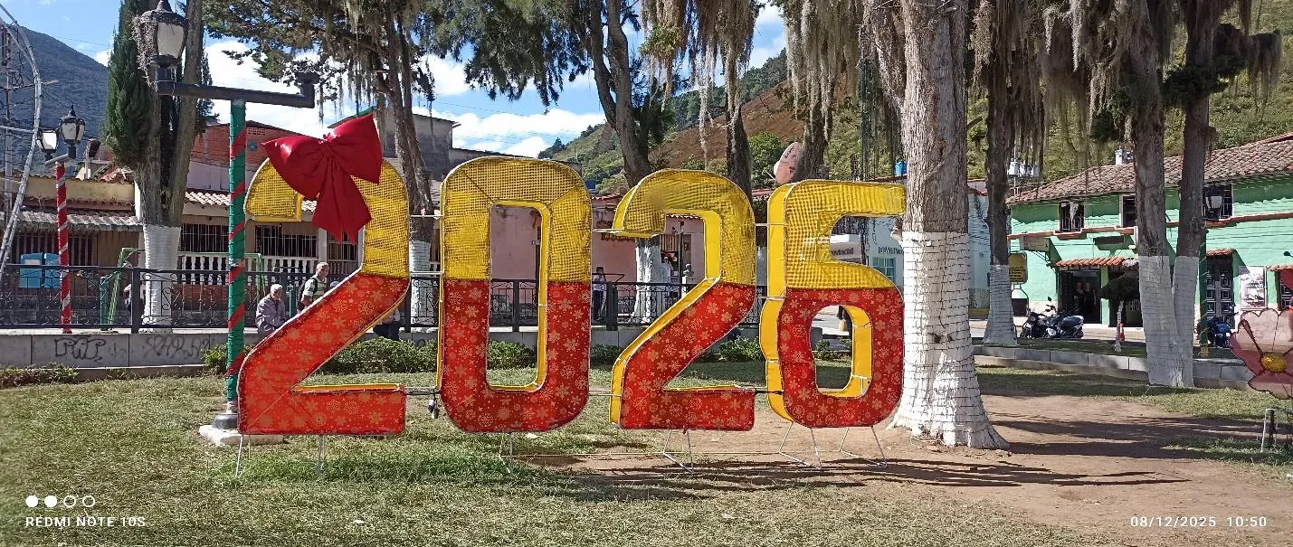 Las cifras «2026», montadas en colores en la plaza de Timotes entre los árboles podados.
