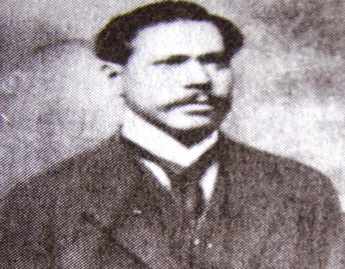 Retrato fotográfico antiguo de un hombre joven, de traje oscuro y bigote, en la página que la crónica dedica al centenario de la investidura de monseñor Buenaventura Vivas.