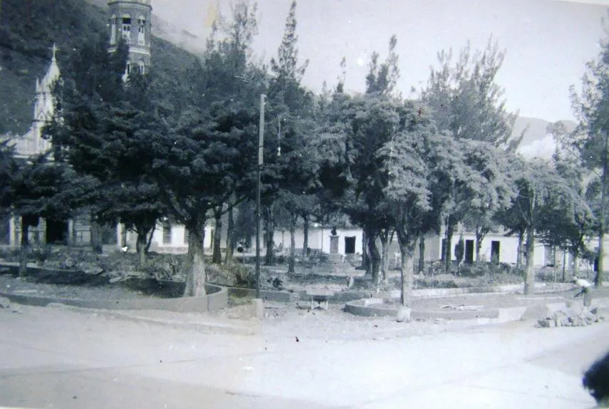 Fotografía antigua de la plaza de Timotes con sus árboles crecidos y las casas bajas del costado.