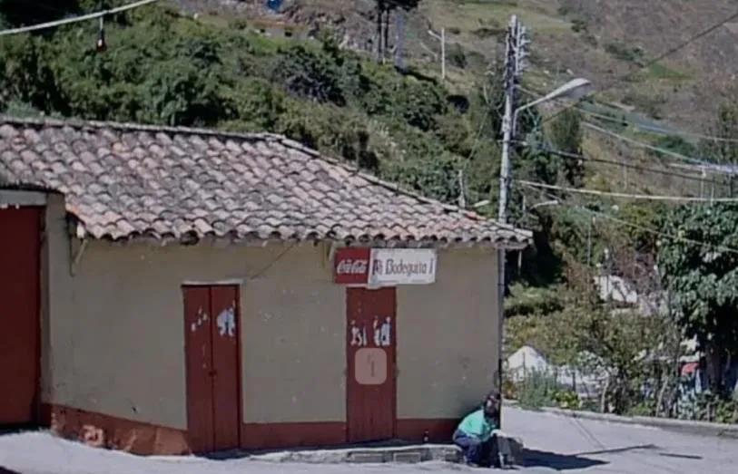 Casa de tapia y teja a la orilla de la vía en La Venta, con su aviso de bodega en la pared encalada.