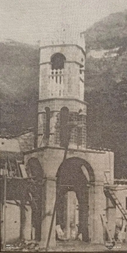 Fotografía antigua en sepia de la torre de la iglesia, con los andamios y la estructura todavía a la vista.