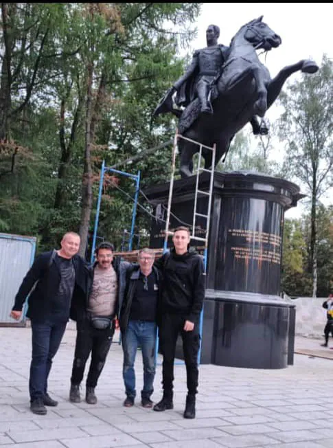 Cuatro hombres posan ante la estatua ecuestre de Bolívar, con el andamio aún en pie.