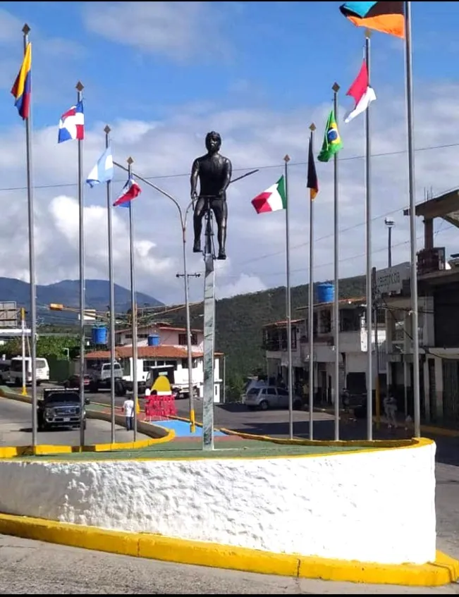 El monumento en la isleta de la avenida, rodeado de astas con banderas de varios países.