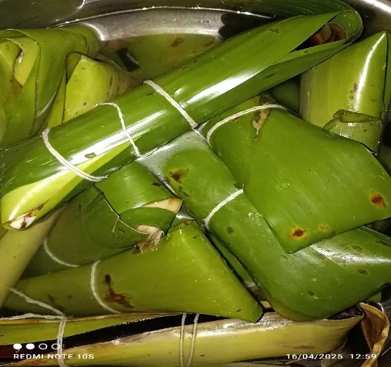 Masas envueltas en hojas y atadas con pabilo, amontonadas en una olla.