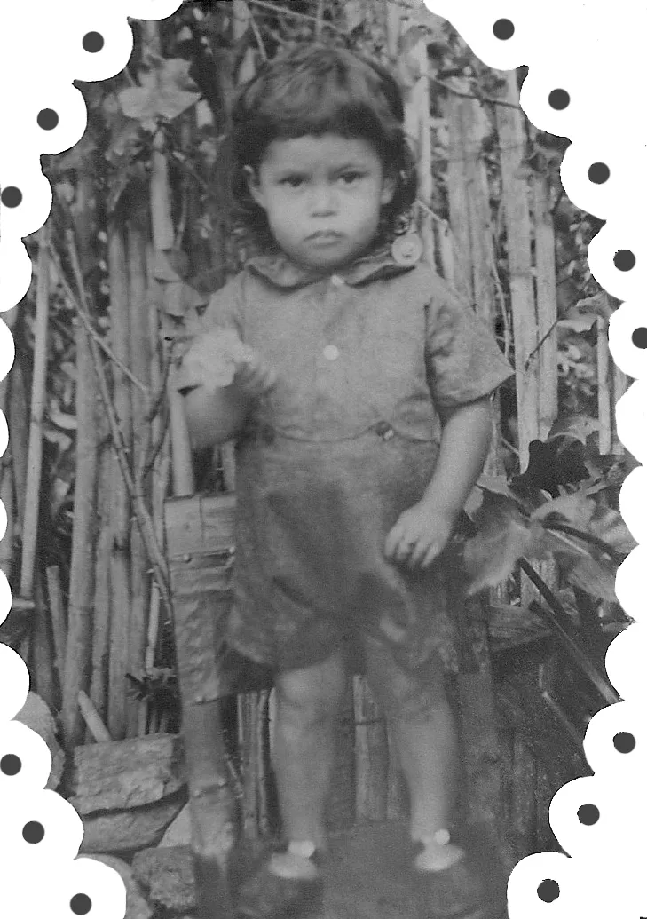 Fotografía antigua de un niño de pie, en un marco ovalado de borde dentado.