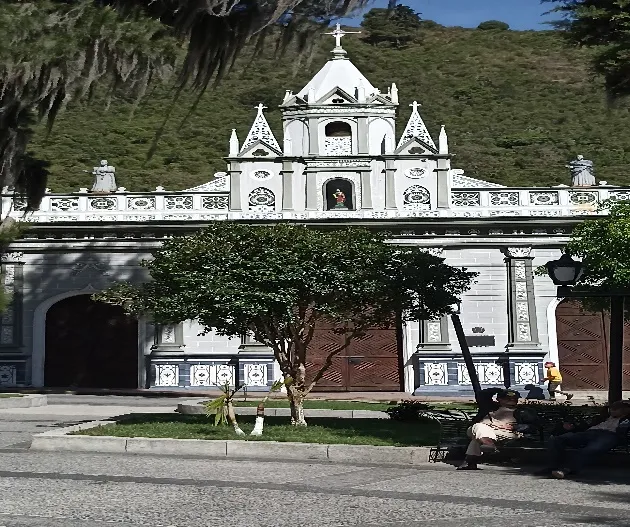 El frontis de la Basílica con su remate calado y la imagen de Santa Lucía en la espadaña, desde la acera de la plaza.