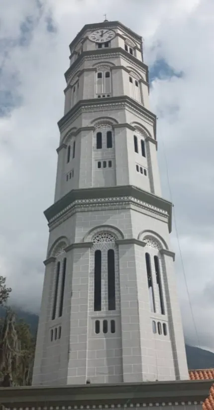 La torre octogonal del reloj de la Basílica, de abajo arriba, contra el cielo nublado.