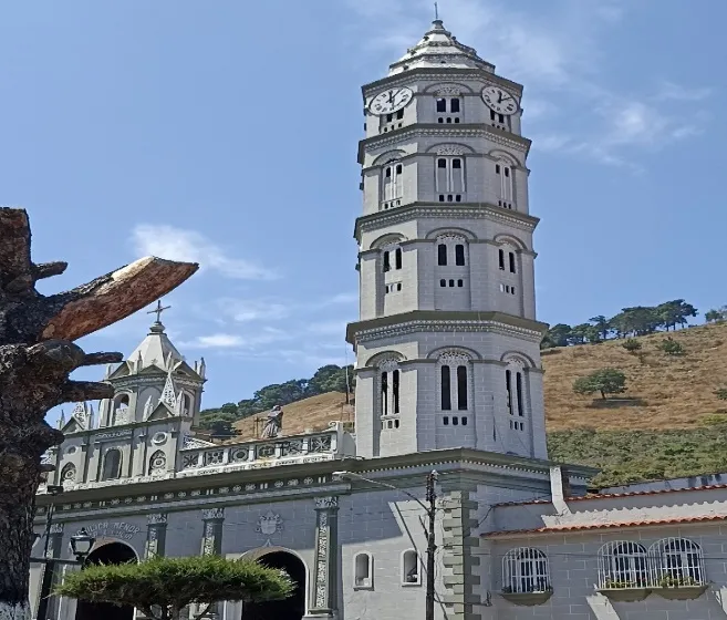 La torre y la fachada de la Basílica desde la esquina de la plaza, con el cerro seco detrás.