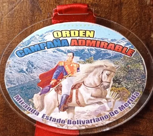 La medalla de la Orden Campaña Admirable del municipio Miranda, con el Libertador a caballo sobre el páramo nevado y su cinta roja.