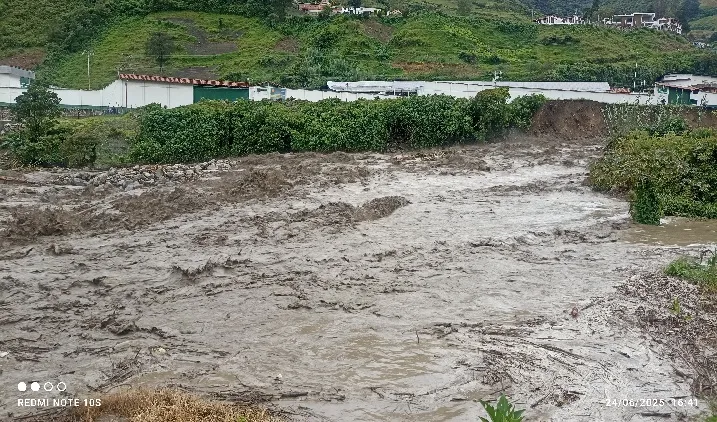 El río bajando crecido y ancho junto a los sembrados y los invernaderos.