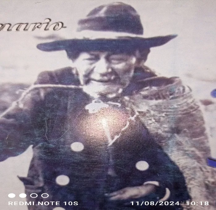 Reproducción impresa de la fotografía de un anciano de sombrero y ruana, con el reflejo del flash sobre el papel.