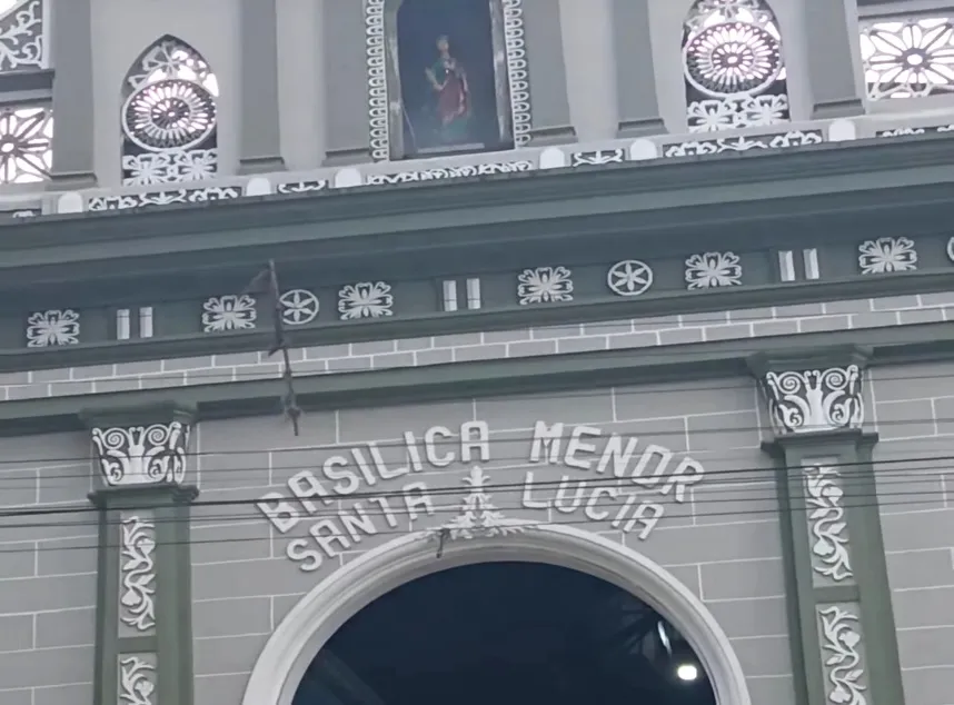 El frontispicio de la Basílica Menor Santa Lucía, con su nombre en letras sobre el arco y el cuadro de la patrona en lo alto.