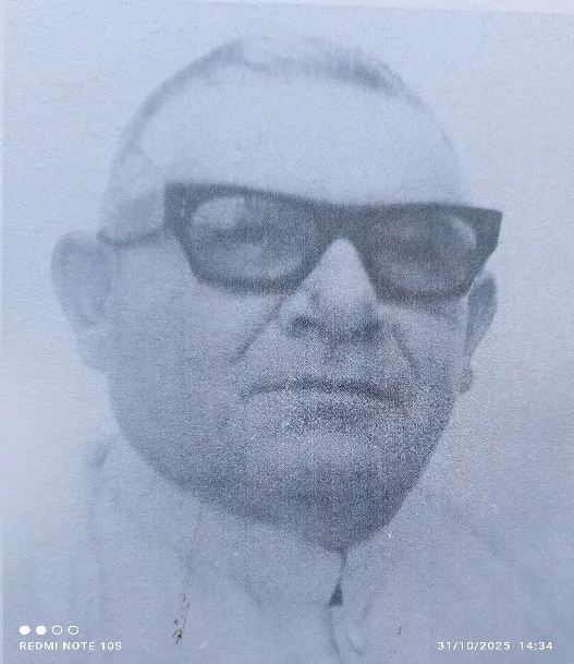 Retrato impreso, muy tramado, de un hombre de lentes oscuros y traje.