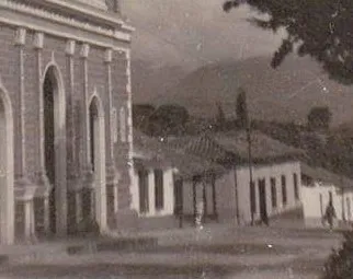 Detalle antiguo de la esquina de la iglesia y la hilera de casas de teja que bajaban por la calle.