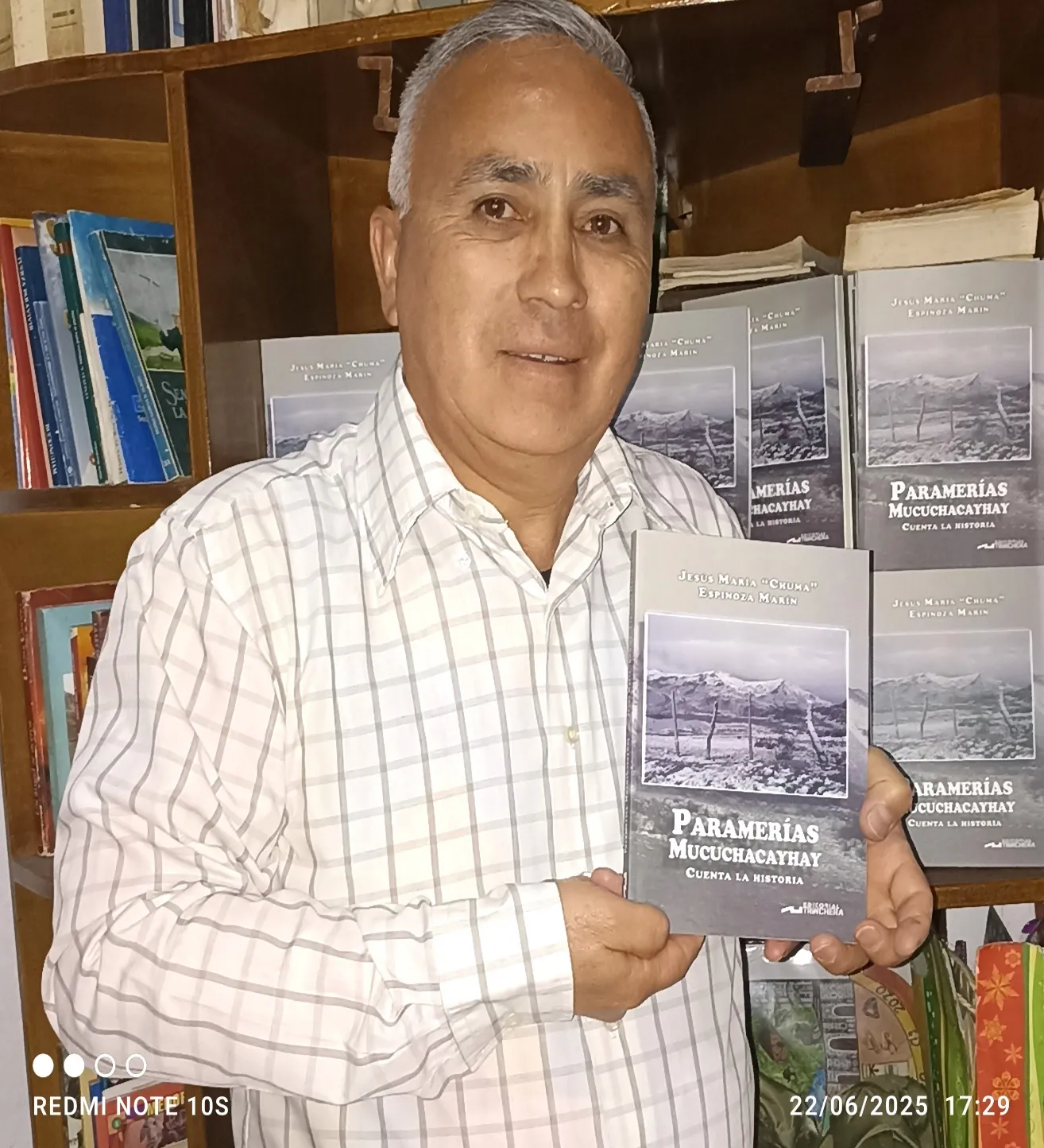 El cronista muestra «Paramerías Mucuchacayhay cuenta la historia» ante el estante lleno de ejemplares.