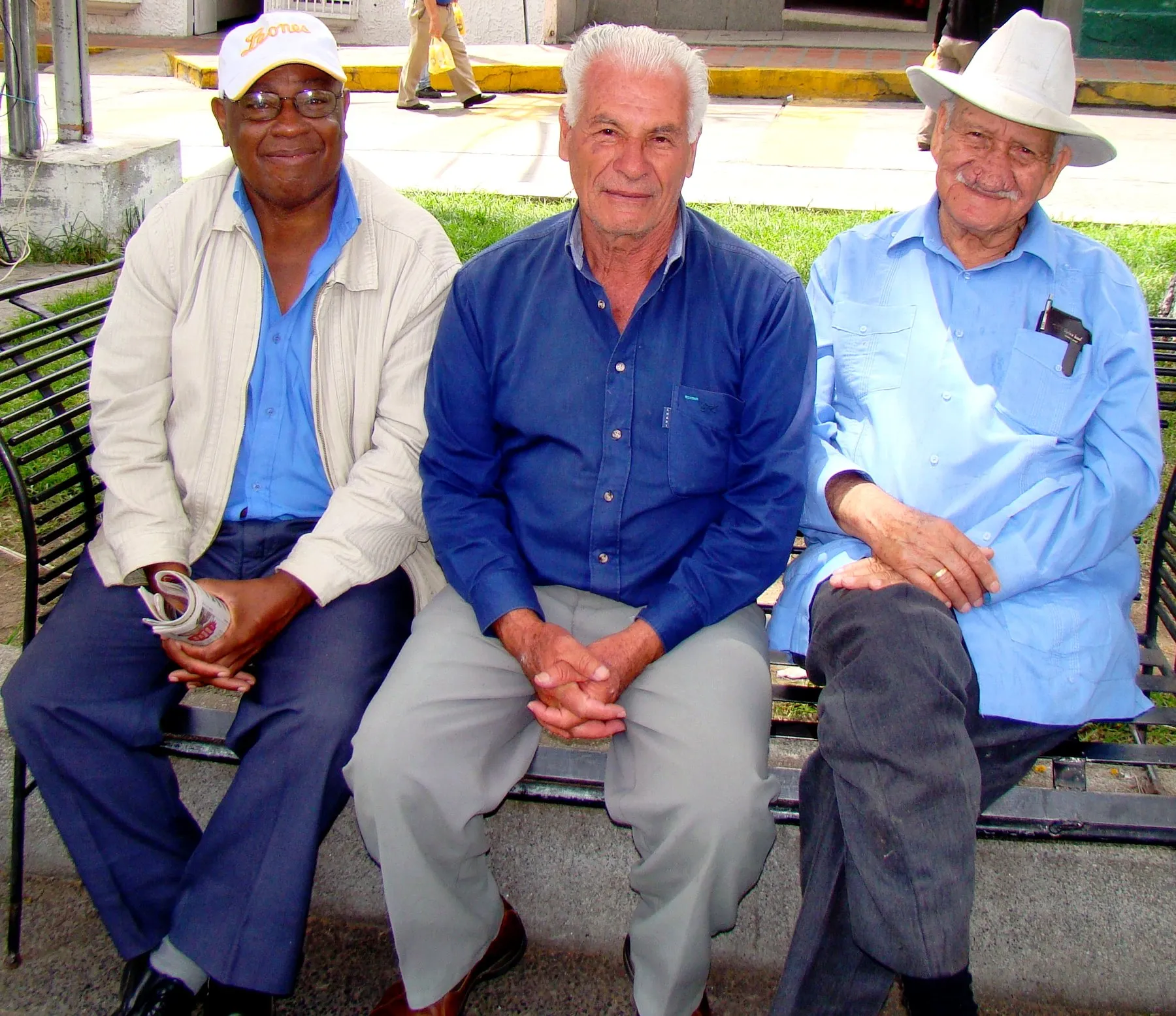Tres señores conversando en un banco de la plaza: la tertulia de todos los días.