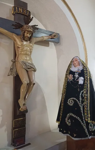 Un Cristo crucificado y una Dolorosa de manto negro: la imagen que acompaña, en el original, los versos de duelo por los jóvenes.