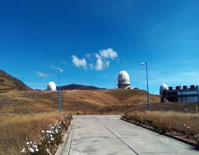 El camino de entrada al observatorio, con las cúpulas bajo el cielo azul del páramo.