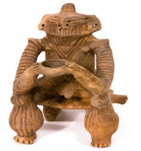 Figura de cerámica sentada en su banco, con una vasija entre las manos.