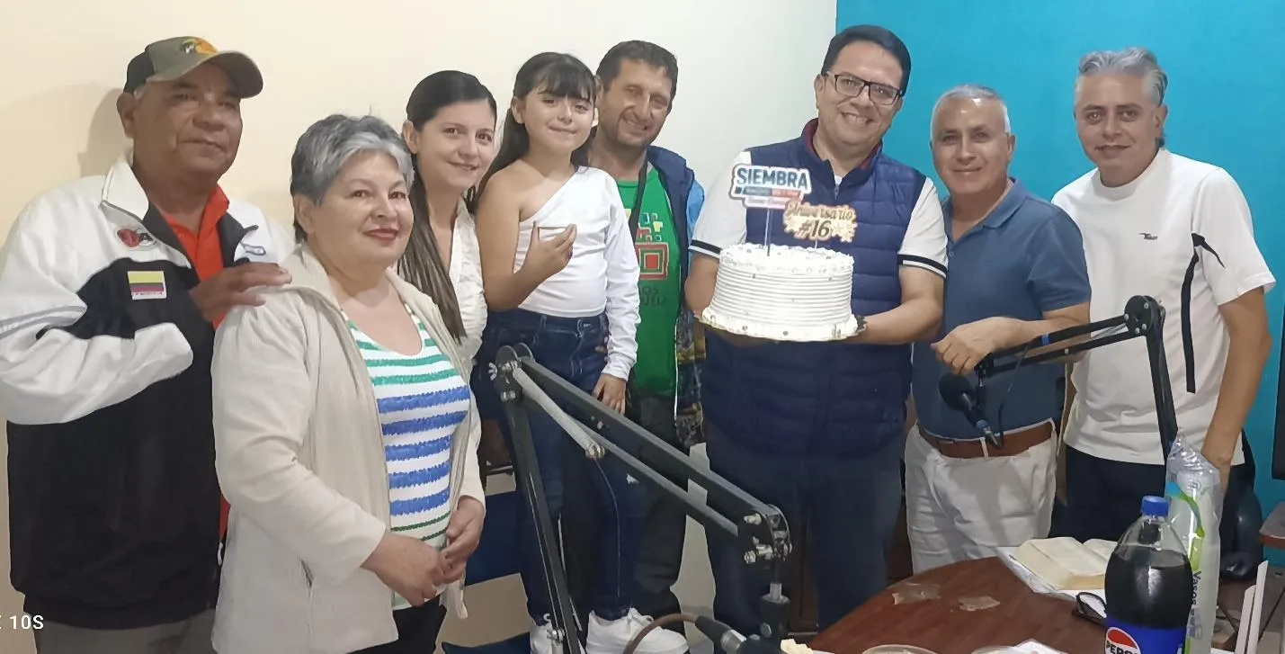 Directivos, locutores y personal de Siembra 89.1 FM con la torta del XVI aniversario, en la cabina de la emisora.