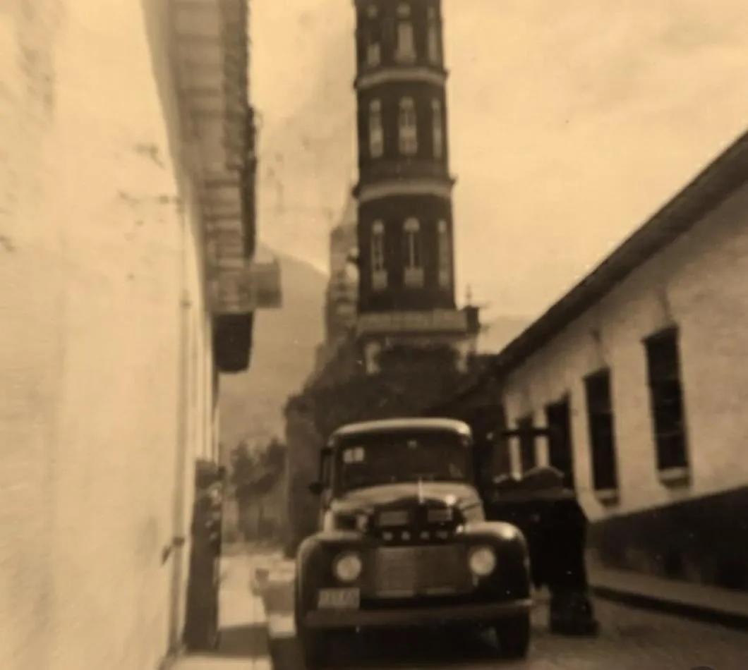 Un camión de la época frente a la torre del templo de Santa Lucía de Timotes.