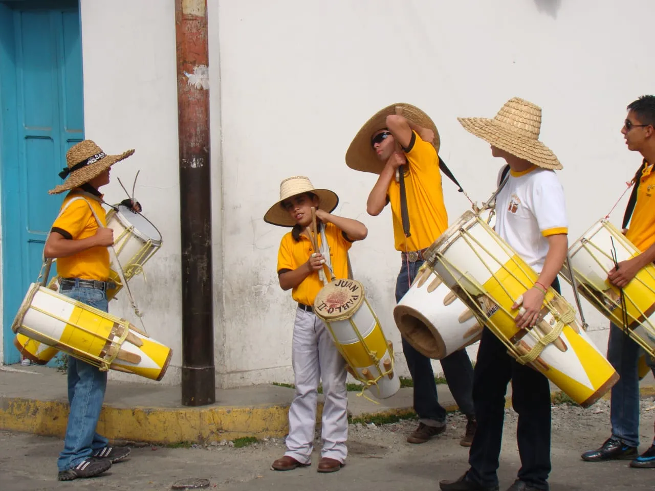 Tamboreros con camisa amarilla y sombrero de cogollo; uno de los tambores lleva escrito «Juan Pablo II».