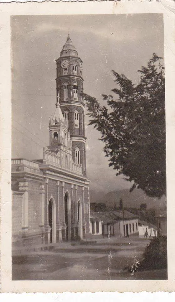 Fotografía antigua de la Basílica Menor de Santa Lucía, con la torre del reloj y la calle todavía sin asfaltar.