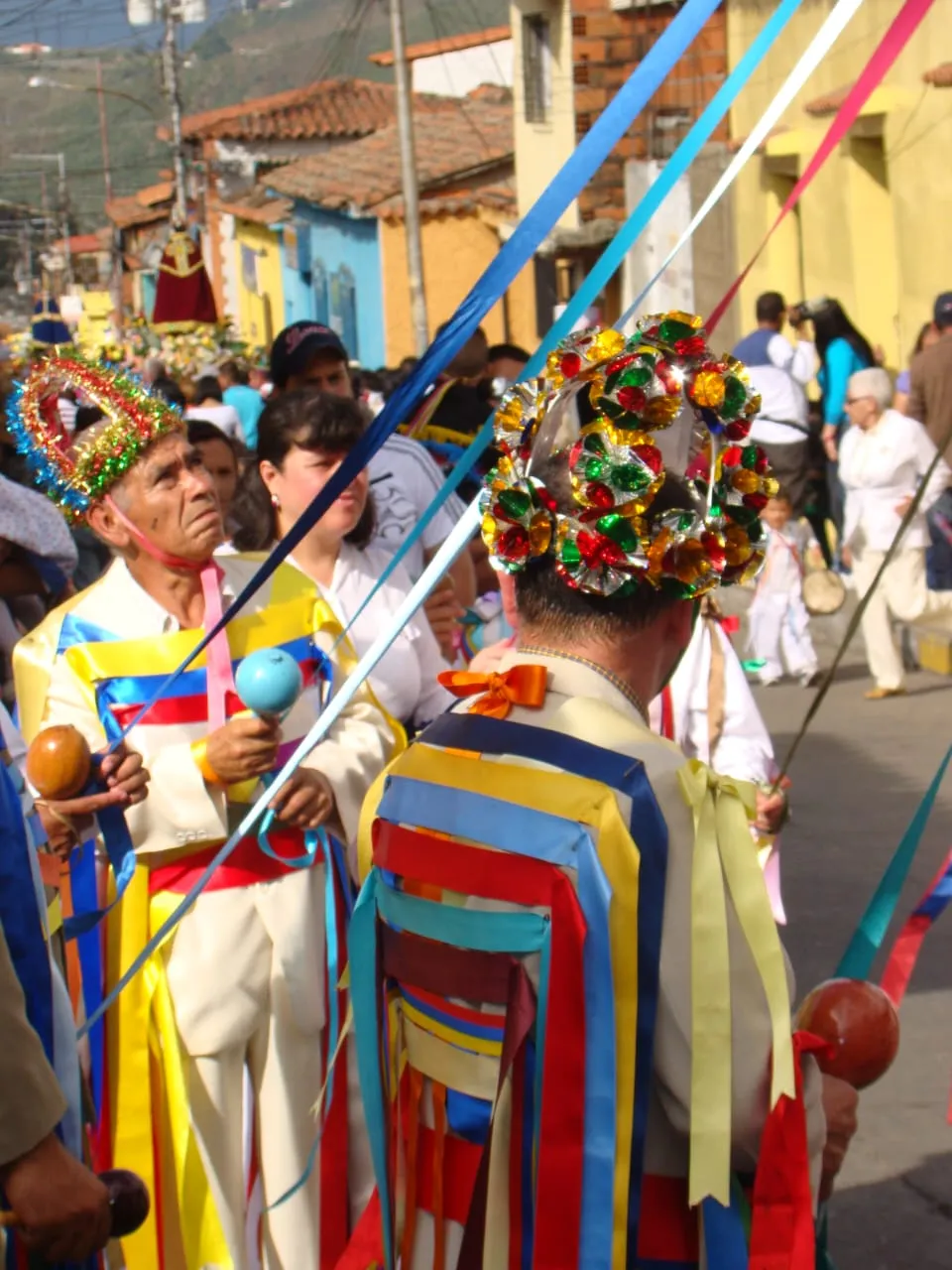 Giros de San Benito con las coronas de rosetones de celofán y las cintas colgando por la espalda, camino de la procesión.