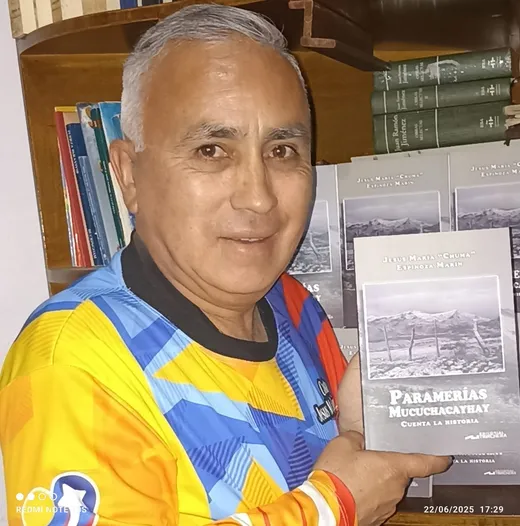 El cronista muestra «Paramerías Mucuchacayhay cuenta la historia» ante su biblioteca, con los ejemplares apilados detrás.
